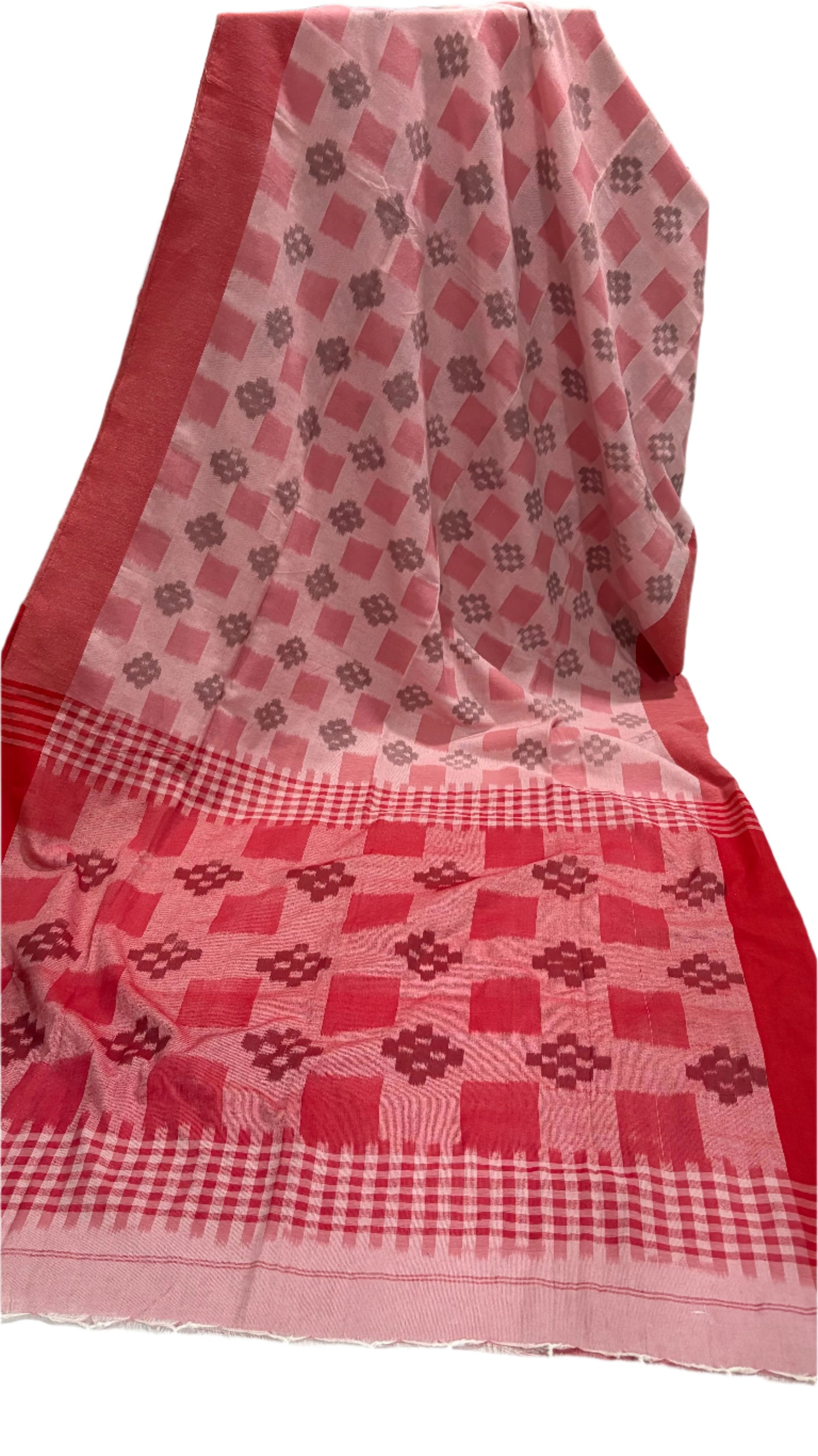 Red and white checkered fabric with geometric patterns on a white surface