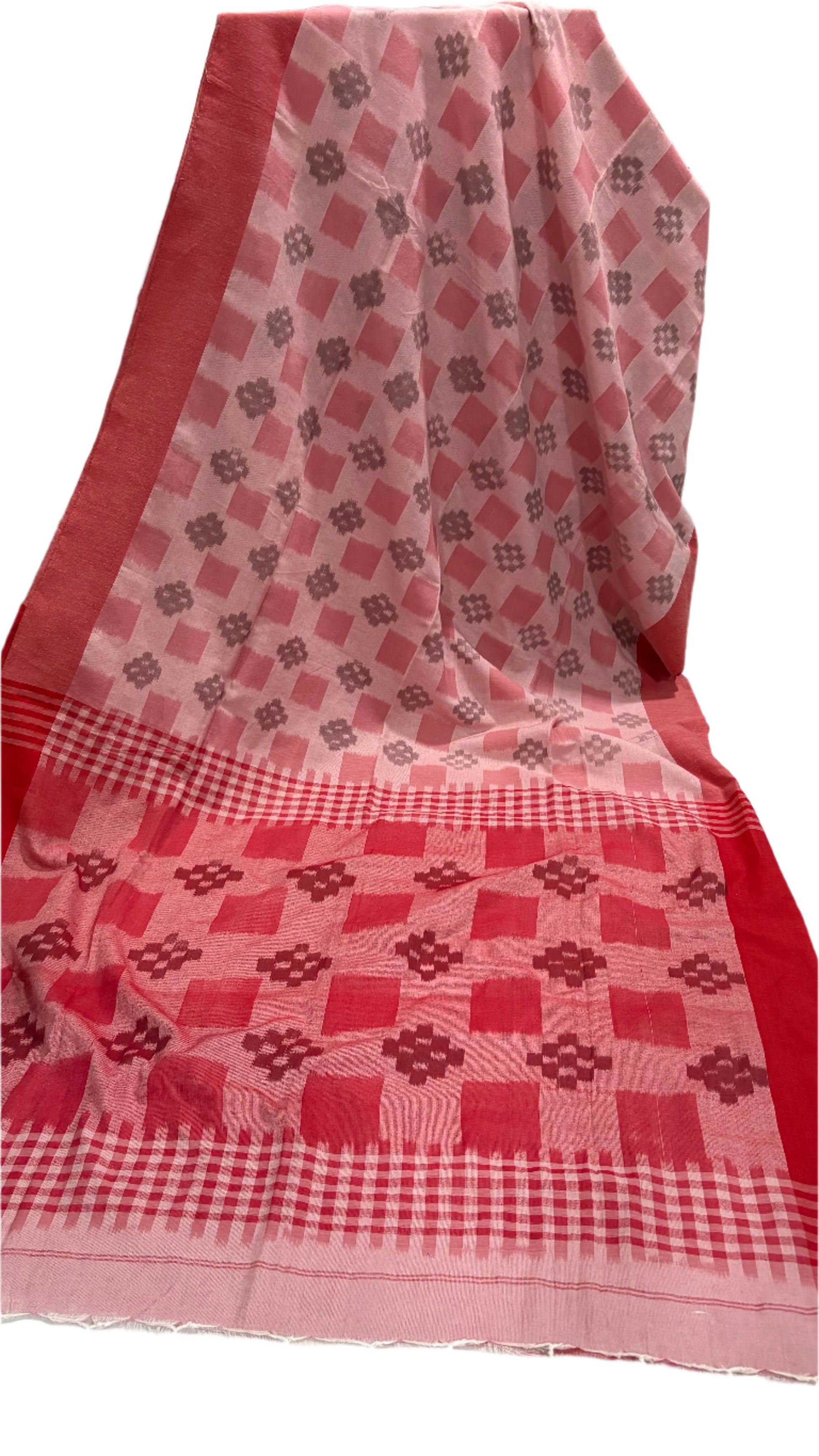 Red and white checkered fabric with geometric patterns on a white surface